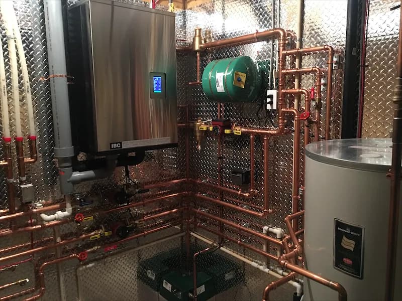 Condensing boiler, expansion tank and hot water cylinder joined by copper piping