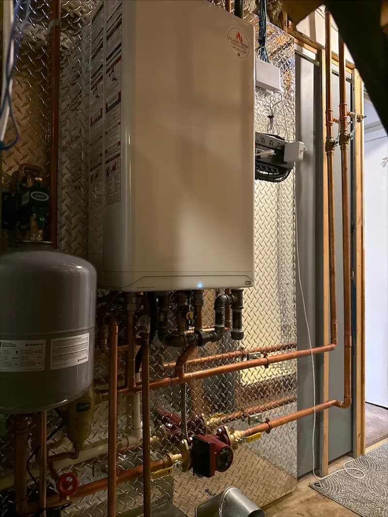 Wall-mounted combination boiler with an expansion tank and copper connections below