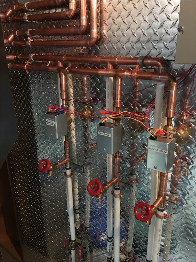 Copper heating piping with red gate valves and insulated lines in a mechanical room
